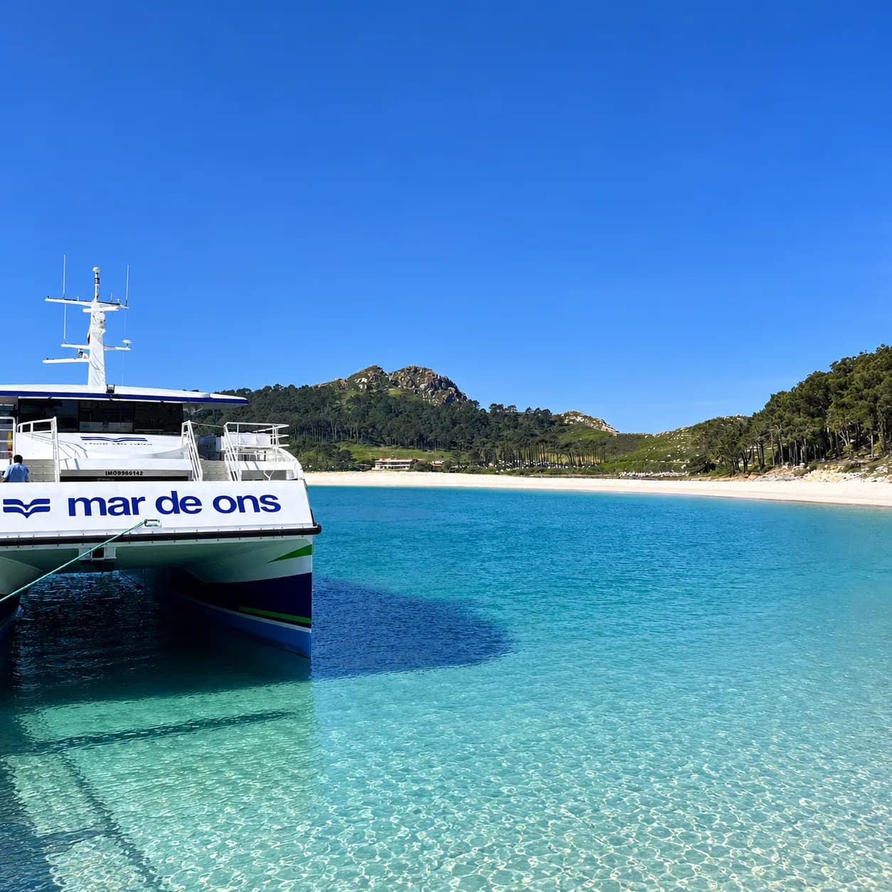 Barco de Mar de Ons frente a una playa de las islas Cíes.