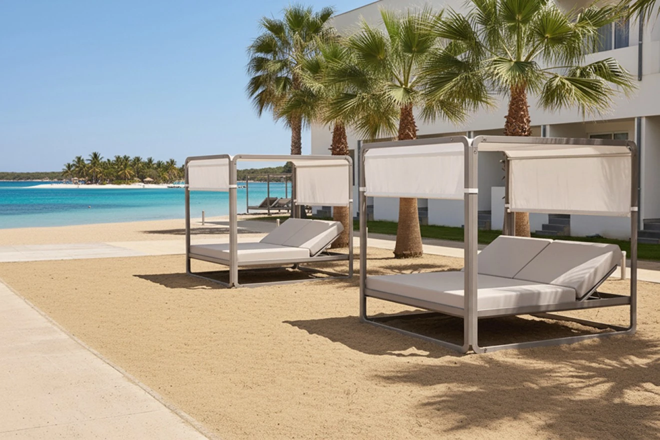 Camas de exterior con dosel junto al agua y las palmeras.